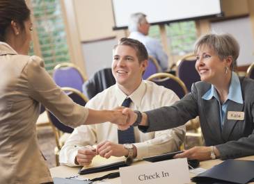 two businesswomen shake hands at a job fair