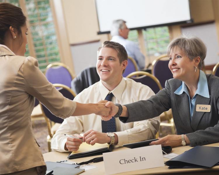 two businesswomen shake hands at a job fair