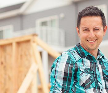 two construction workers smile at a worksite